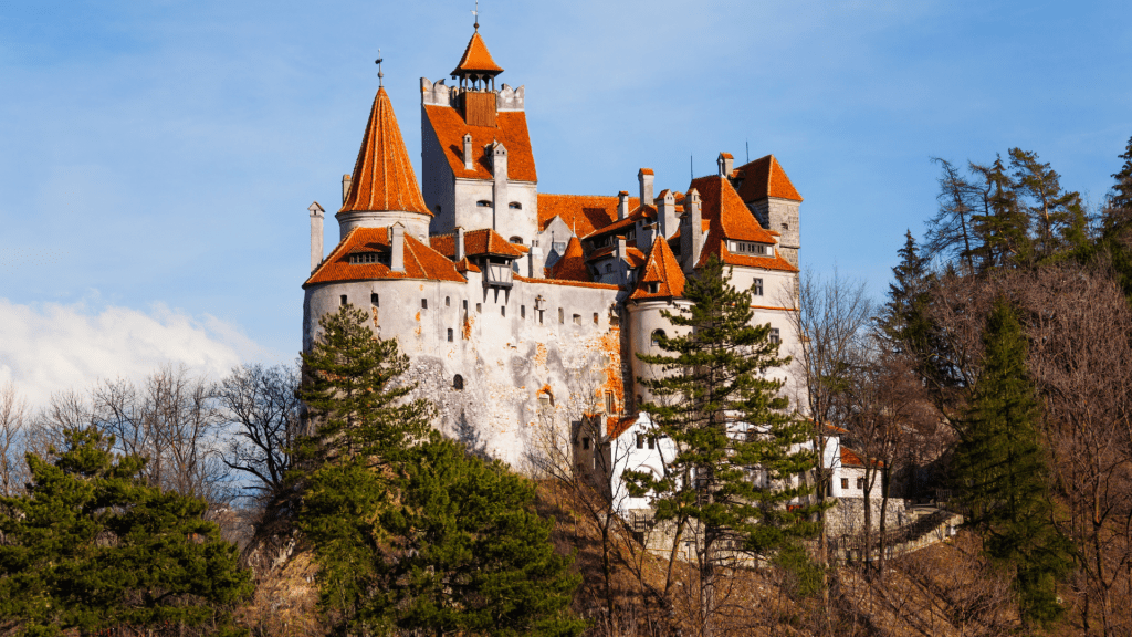 Bran Castle among trees on hill in Romania